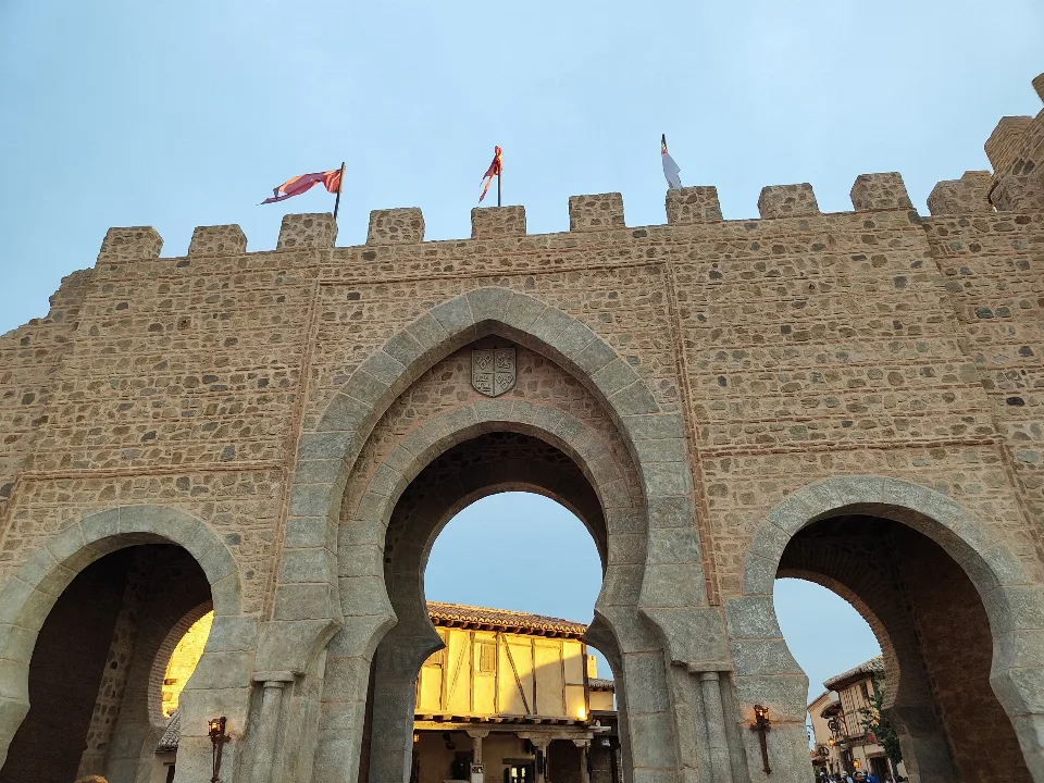 Medieval gate of the Puy du Fou España park lit at dusk, without visitors